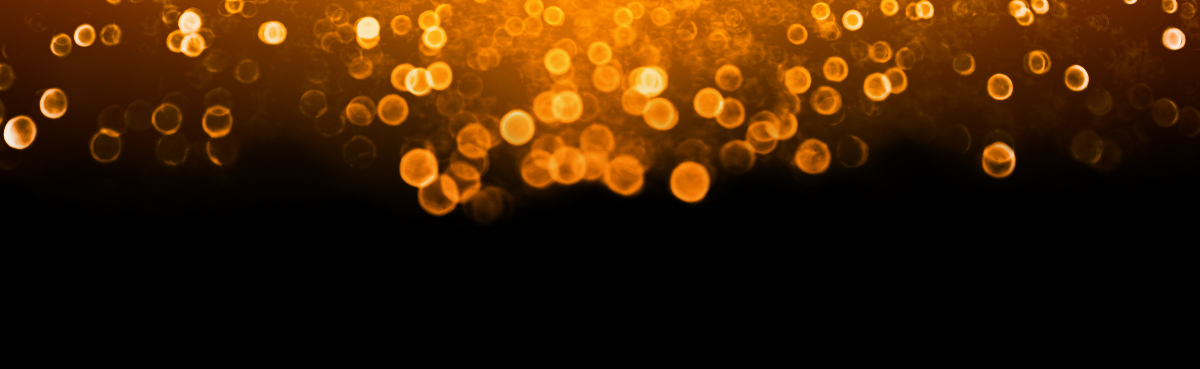 Bokeh lights on a black background with orange and yellow hues
