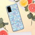 Phone case with a colorful wave pattern on a yellow surface with fruit and leaves.