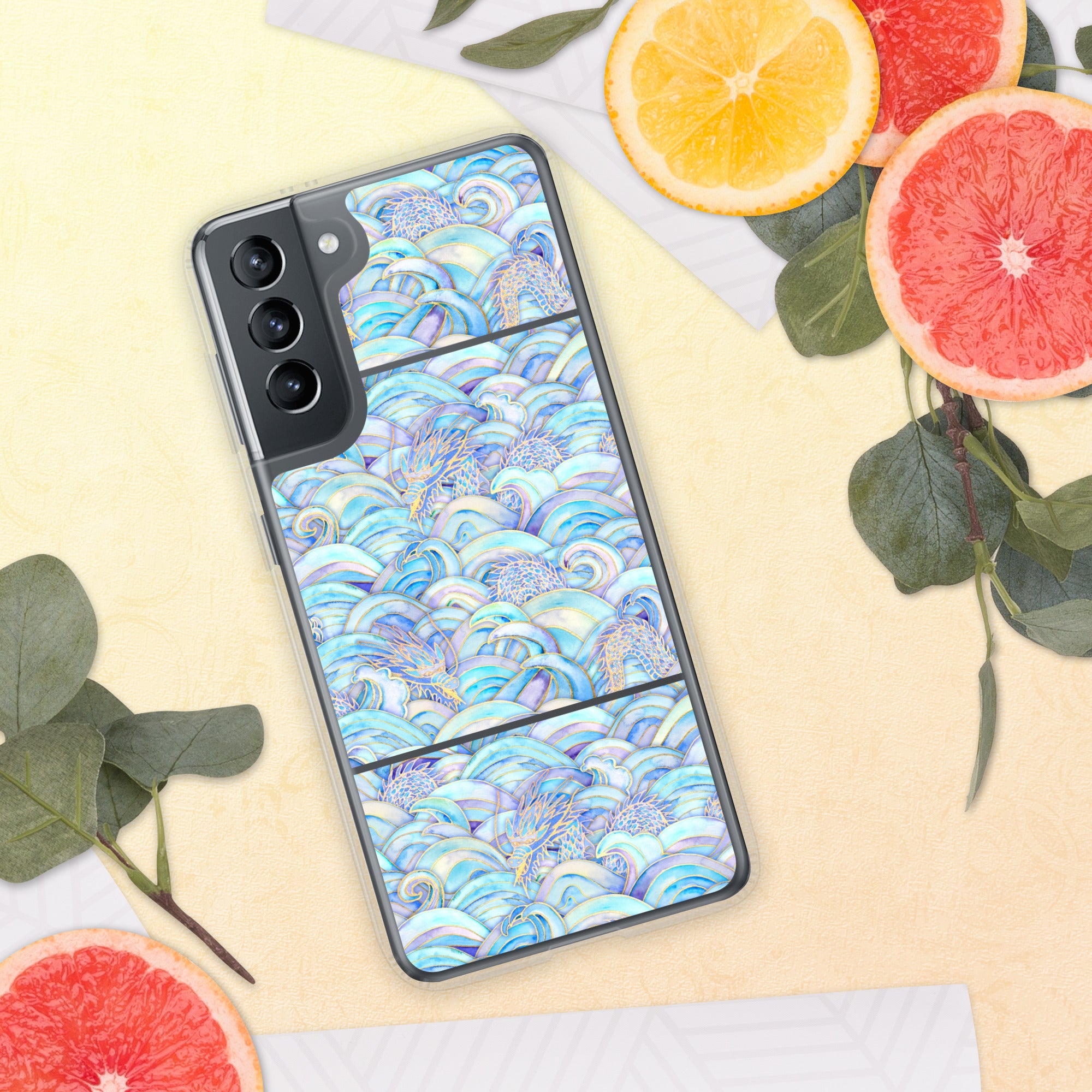 Phone case with a colorful wave pattern on a yellow surface with fruit and leaves.
