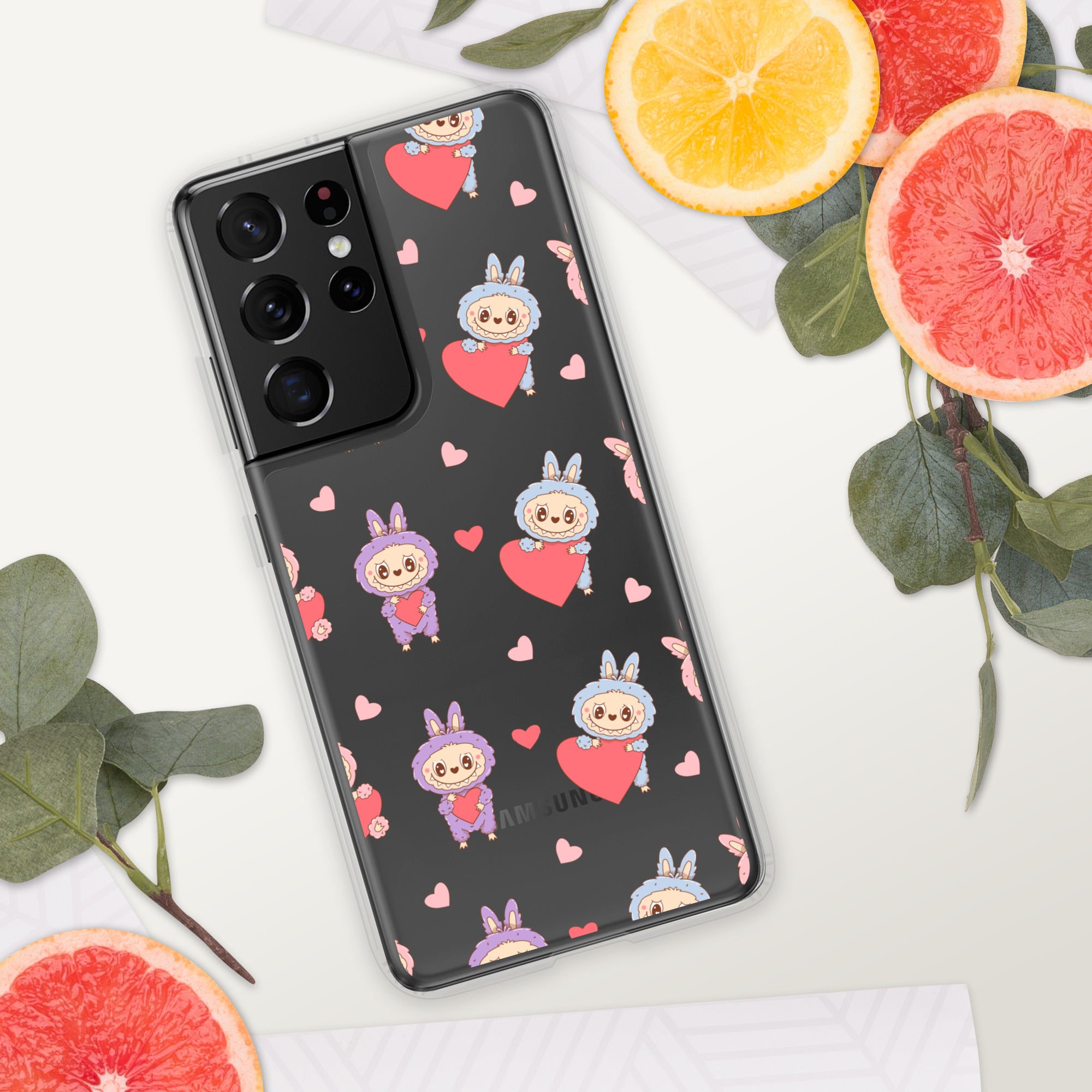 Phone case with cartoon character and heart pattern on a white surface with fruit and leaves.