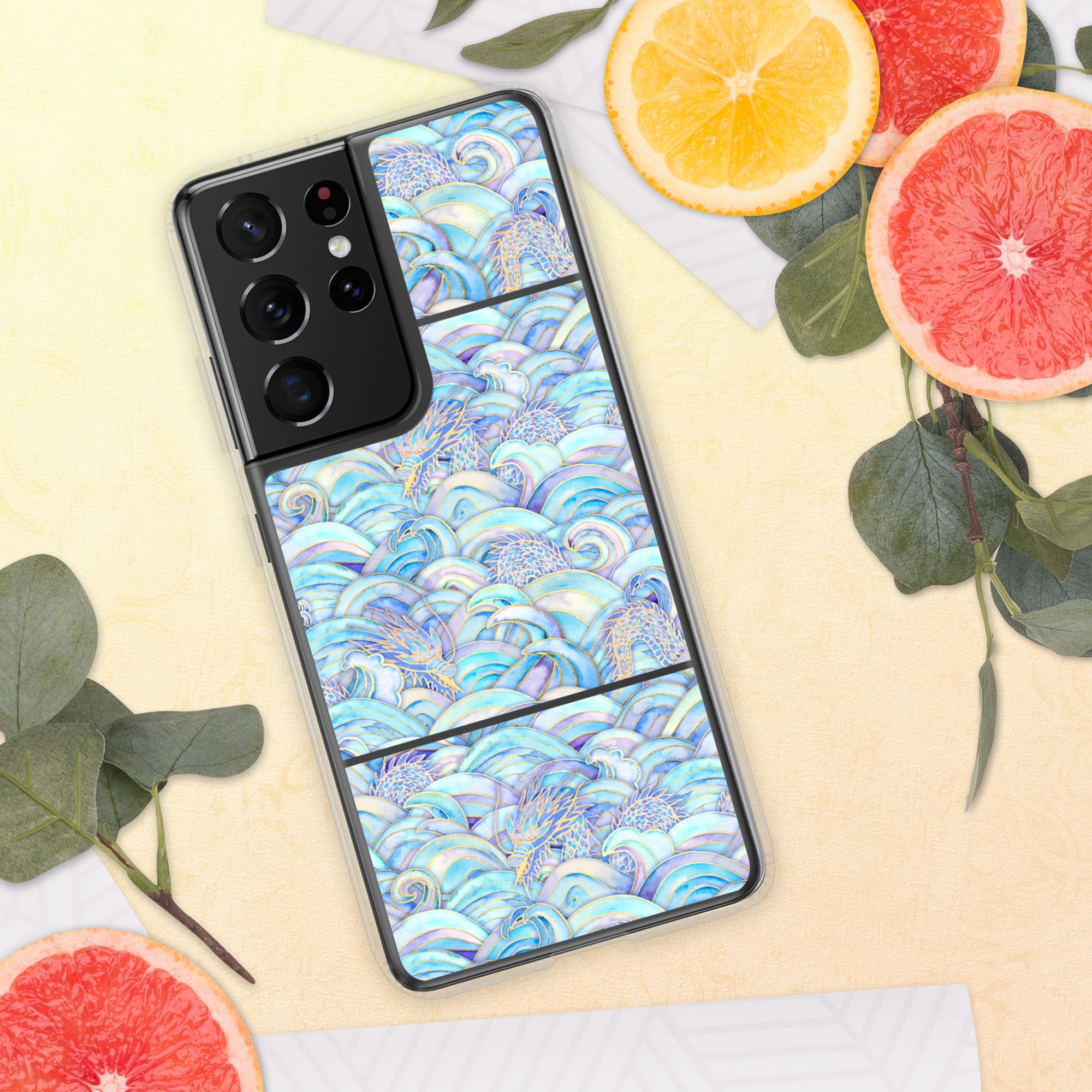 Phone case with a blue wave pattern on a yellow surface with fruit and leaves.