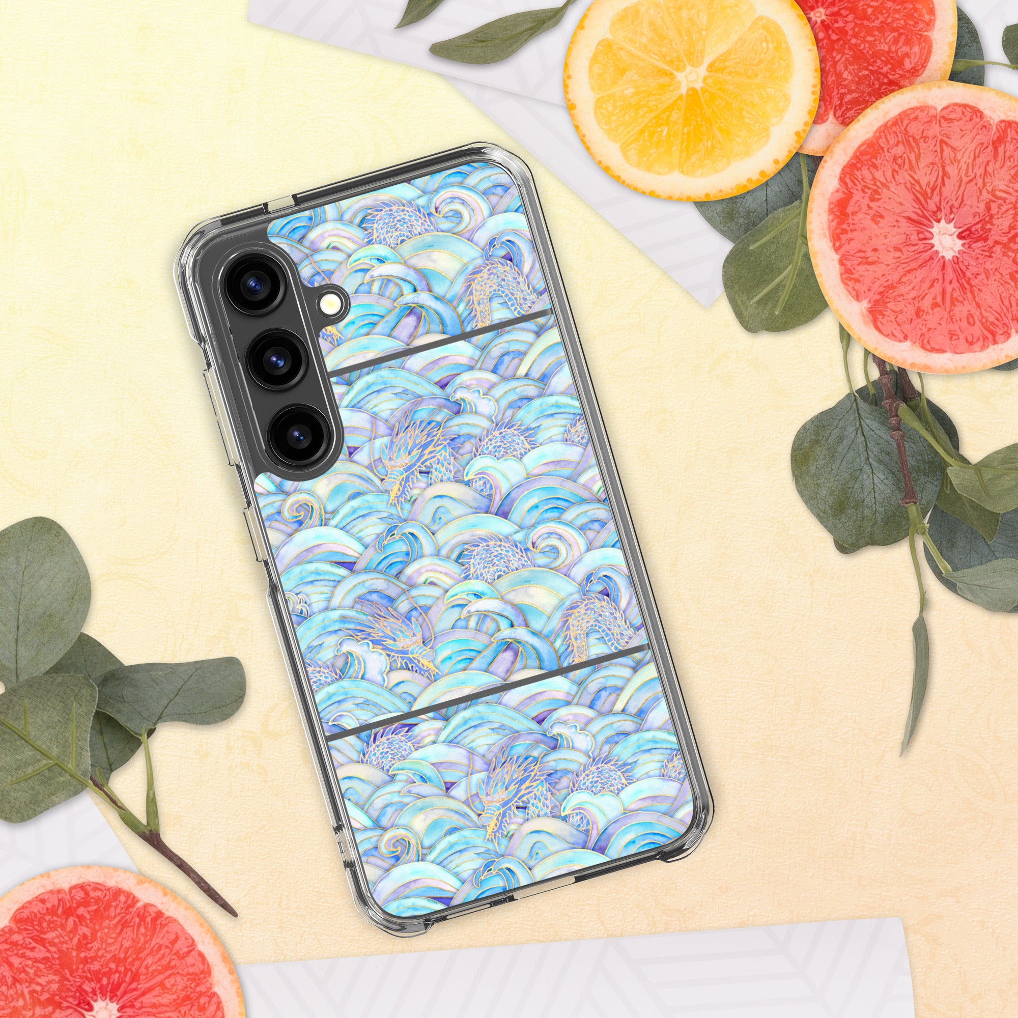 Phone case with a colorful wave pattern on a yellow surface with fruit and leaves.