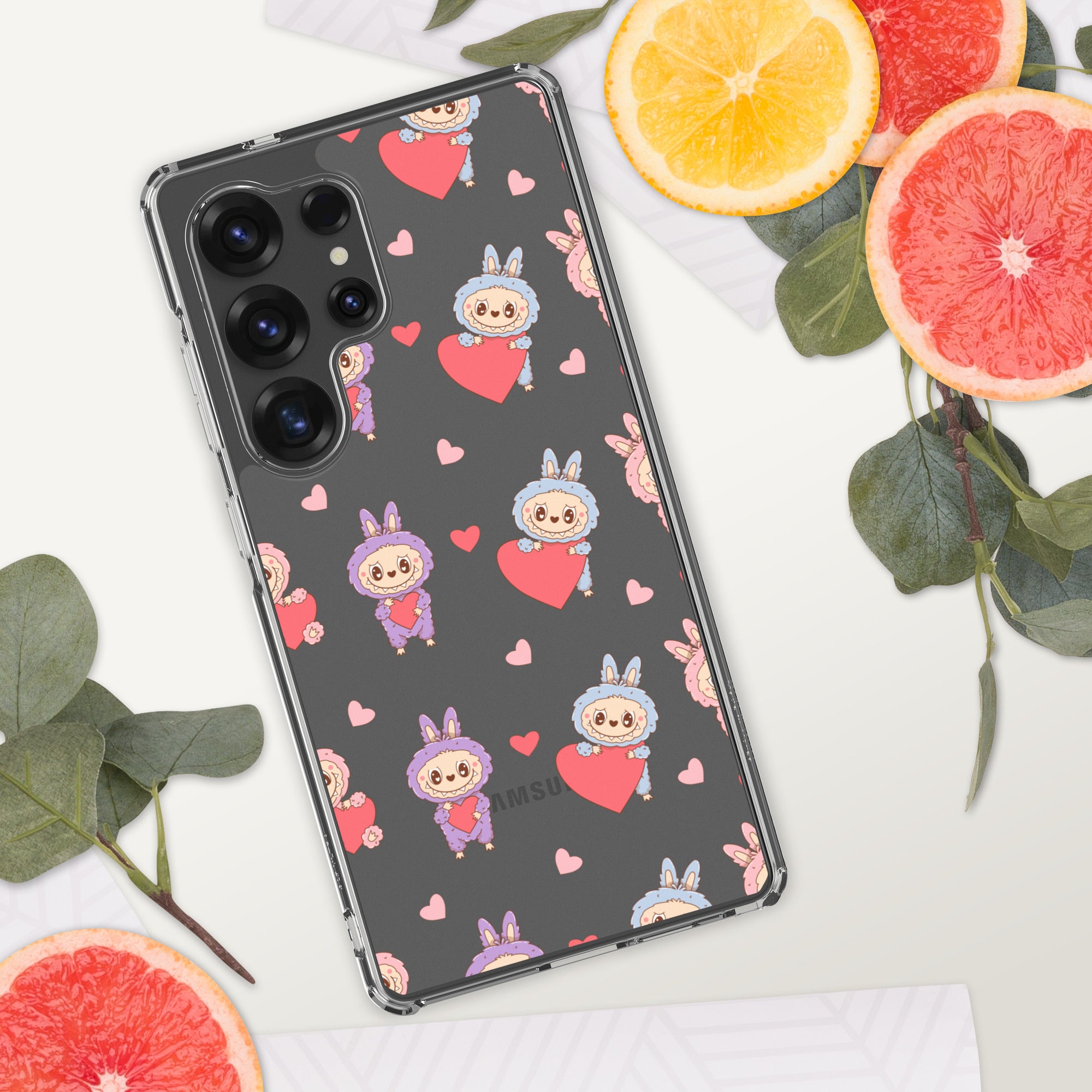 Phone case with cartoon character and heart pattern on a white surface with fruit and leaves.