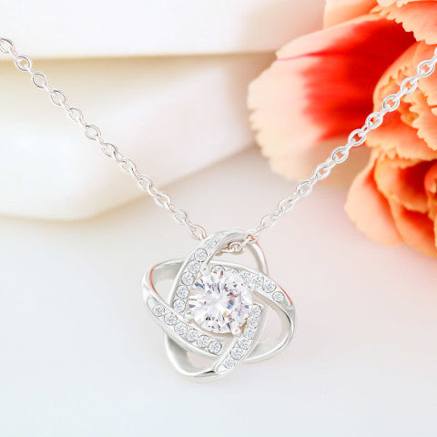 Silver necklace with a heart-shaped pendant on a light background