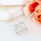 Silver necklace with a heart-shaped pendant on a light background
