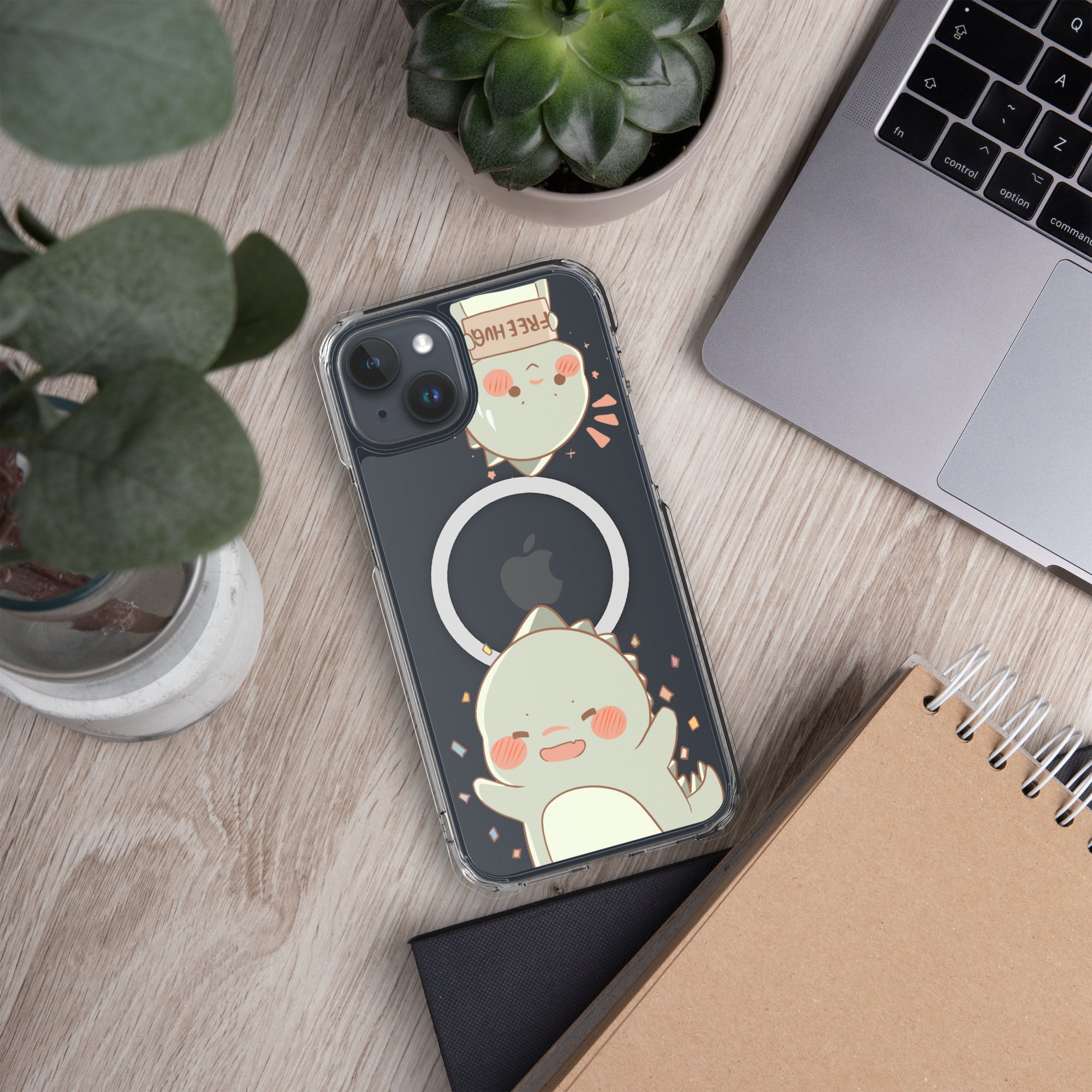 Phone case with cartoon design on a desk with laptop, notebook, and plants