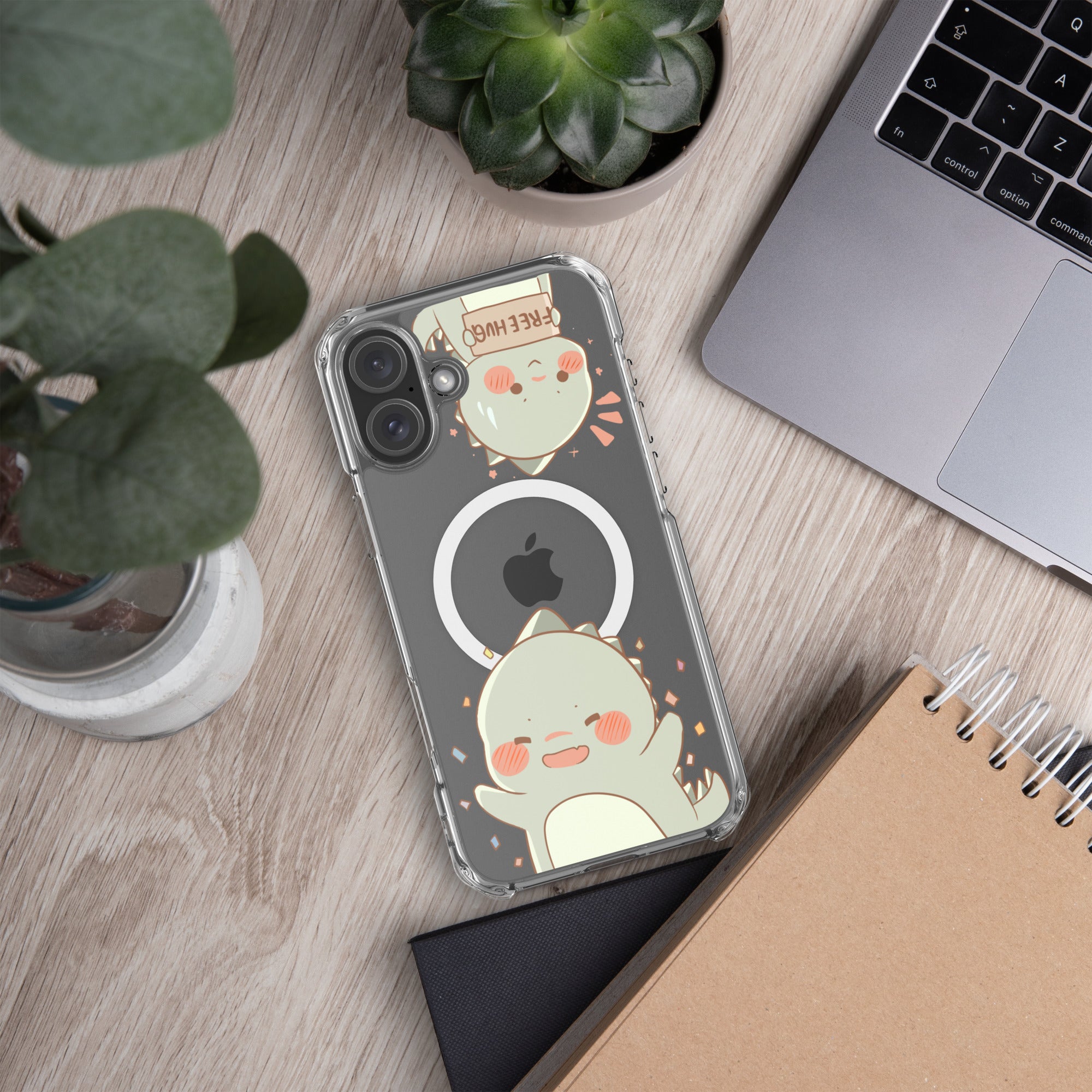 Phone case with cartoon design on a desk with laptop, notebook, and plants